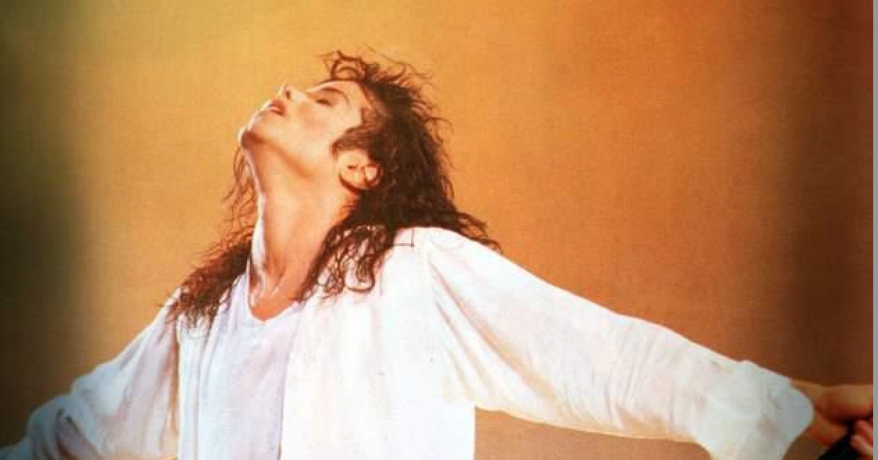 Michael Jackson on stage in white shirt, arms outstretched, head tilted back — the King of Pop in full performance flow