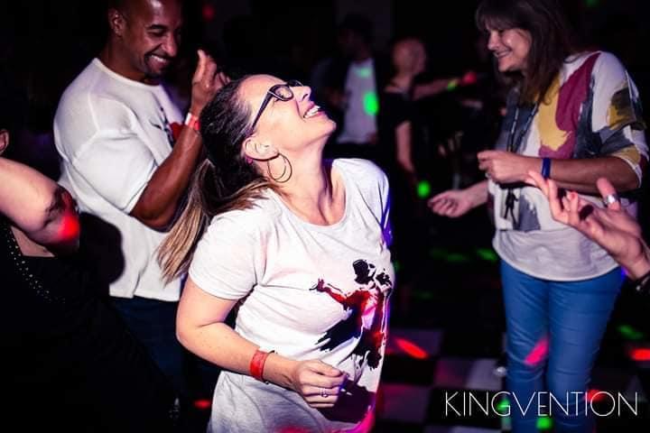 Tasha dancing at Kingvention — a Michael Jackson fan event — eyes closed, lost in the music, surrounded by other fans doing the same.