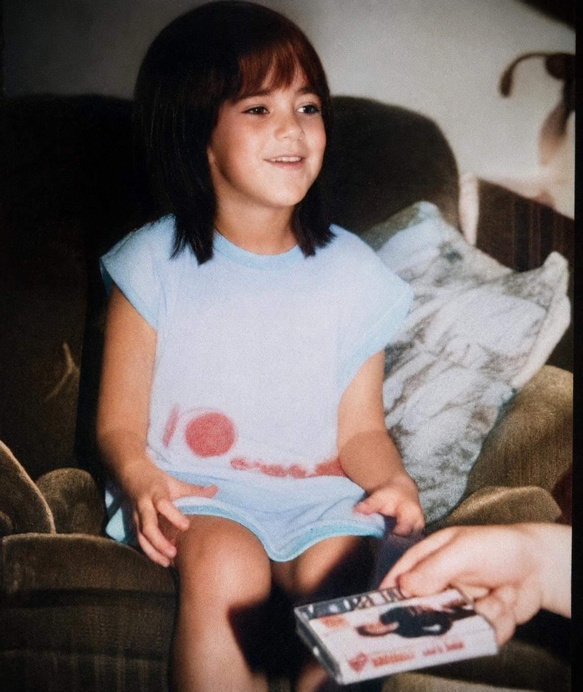 A young Tasha as a little girl — light blue top, dark fringe, soft smile — the child who found comfort in Michael Jackson's music.